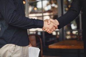 Portrait of cheerful young manager handshake with new employee